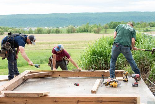 A group of men are working on a wooden structure.