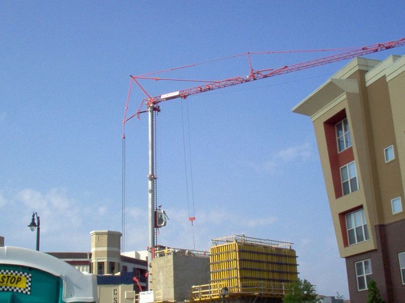 Construction crane over a building under construction on a sunny day.
