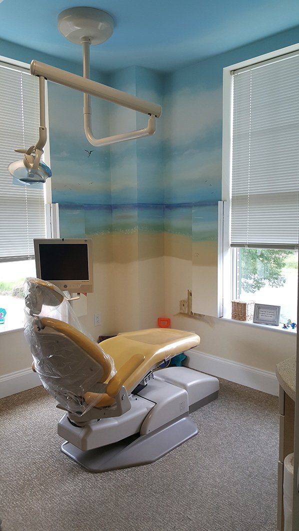 a dental office with a painting of a beach on the wall