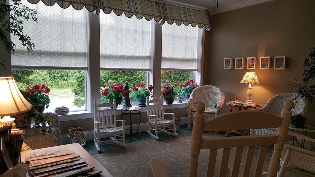 a room with rocking chairs and a table with magazines on it
