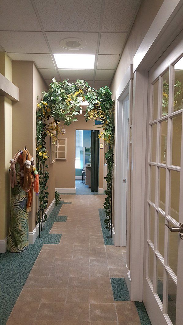 a hallway with stuffed animals and plants hanging from the ceiling