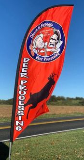 Red flag with Deer Processing Inc. logo featuring a buck, and cartoon butcher figures.