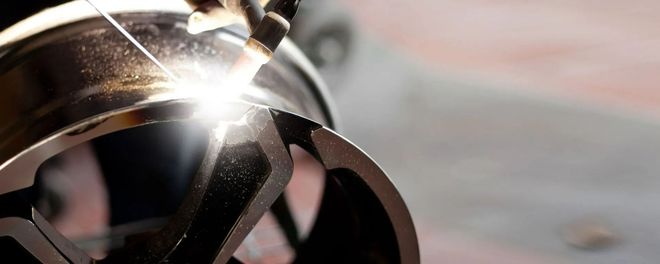 Close-up of a shiny metal wristwatch with bright light reflecting off its surface