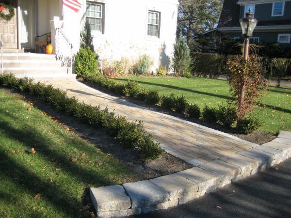 A walkway leading to a house with a flag in the background
