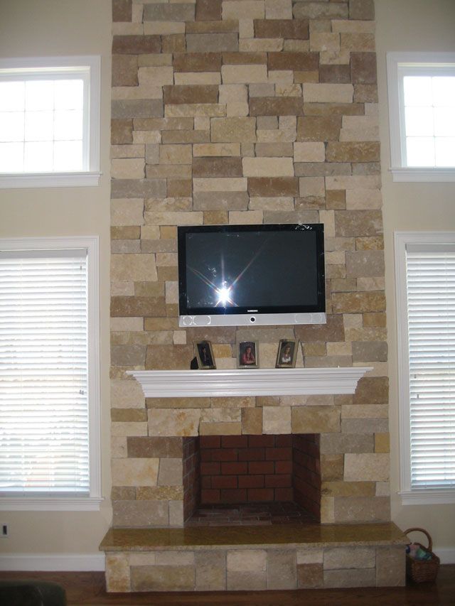 A stone fireplace with a flat screen tv above it