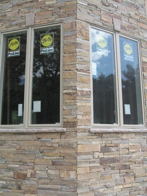 A corner of a brick building with a few windows