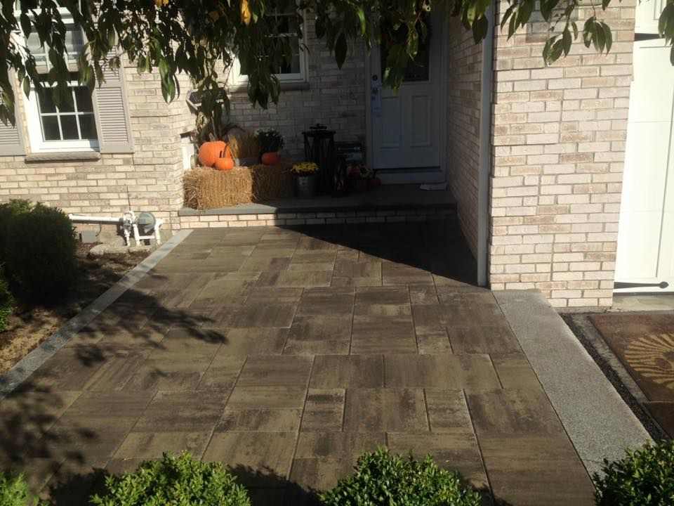 A brick house with a walkway leading to the front door
