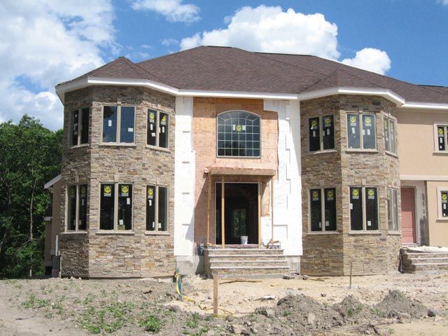 A large house under construction with a lot of windows