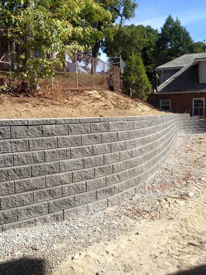 A brick wall is being built in front of a house.