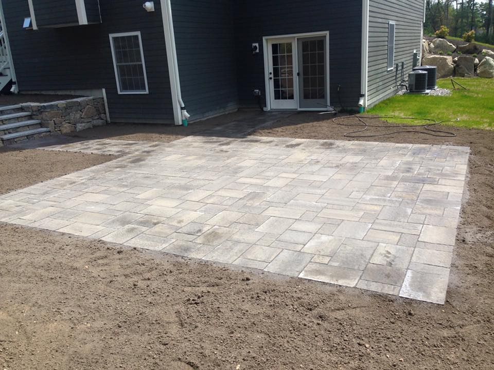 A large patio is being built in front of a house.