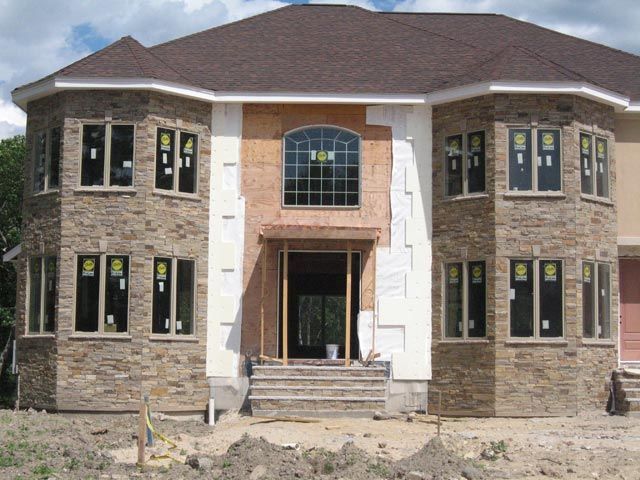 A large house with a lot of windows is under construction