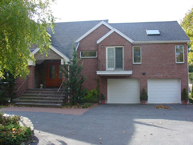 A large red brick house with two white garage doors