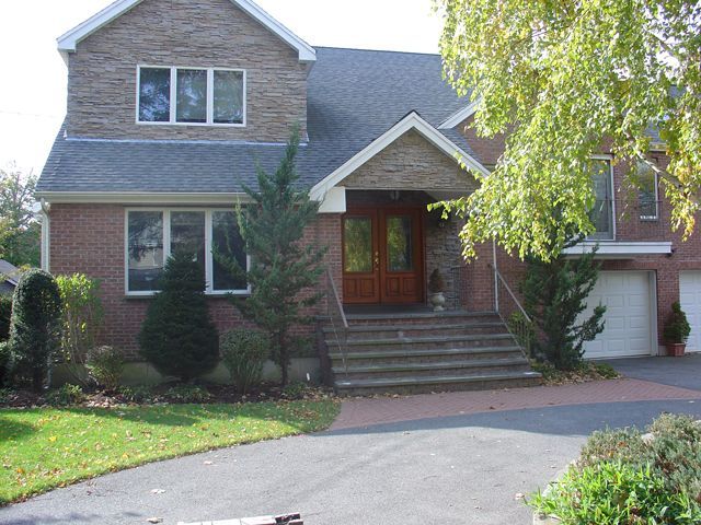 A large brick house with two garages and a driveway
