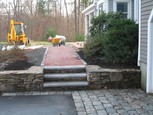 A brick walkway is being built in front of a house