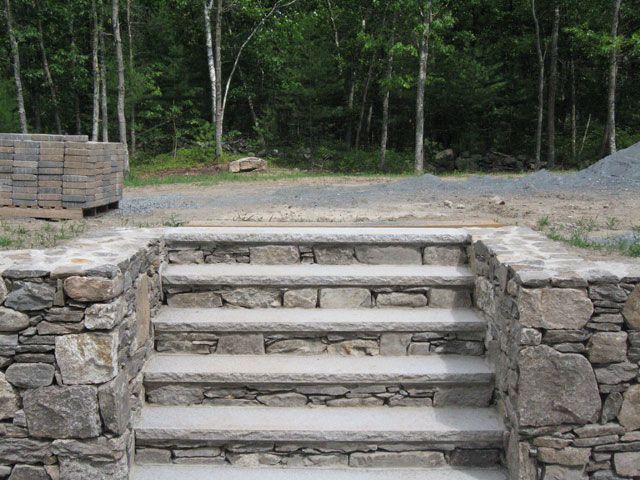 A set of stone stairs leading up to a forest.
