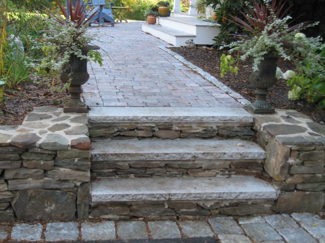 A stone walkway with steps and a stone wall
