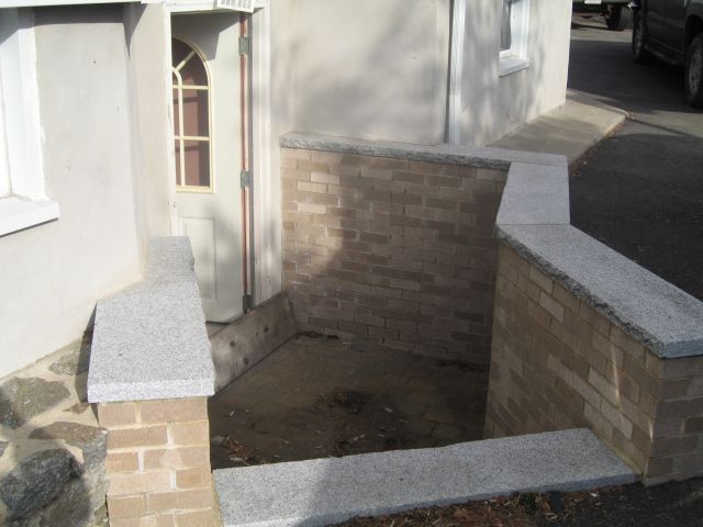 A brick wall with steps leading up to a door