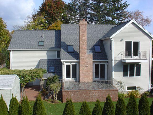 A large white house with a brick chimney on the roof
