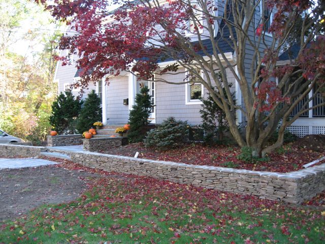A house with a stone wall in front of it