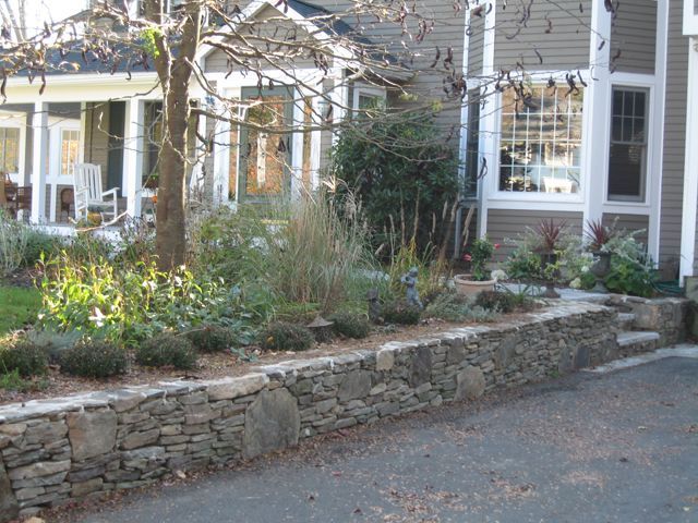 A house with a stone wall in front of it