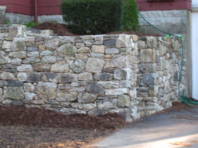A stone wall with a hose attached to it