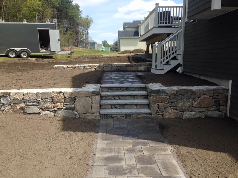 A stone walkway leading to a house with stairs