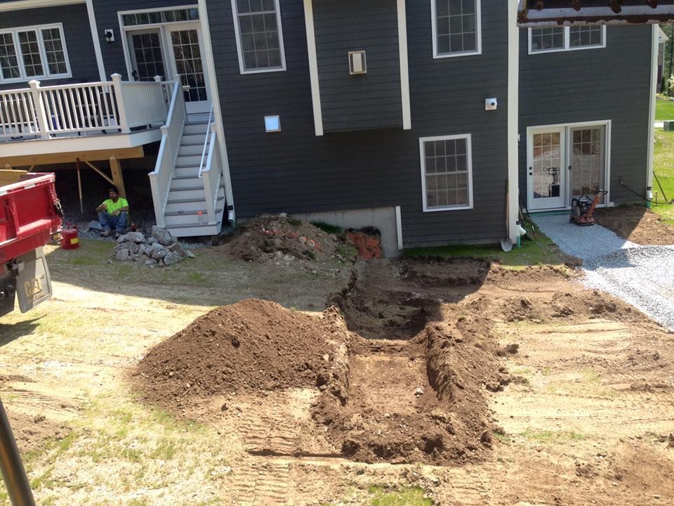 A large pile of dirt is in front of a house