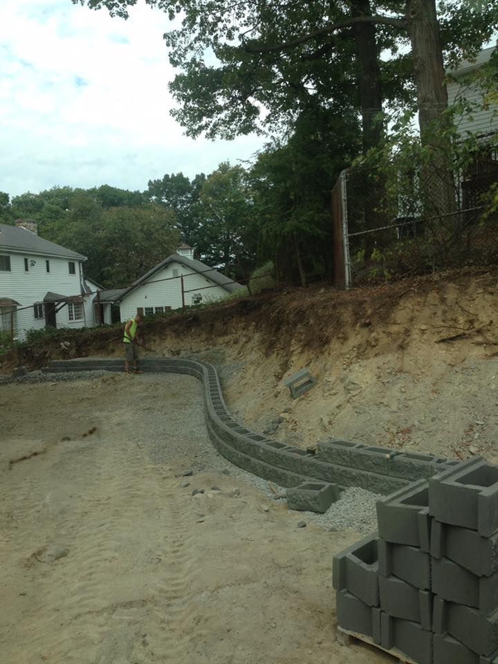A stack of bricks is sitting on the ground in front of a house