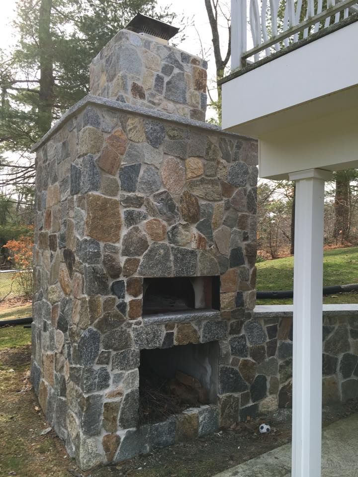 A stone fireplace with a pizza oven underneath it