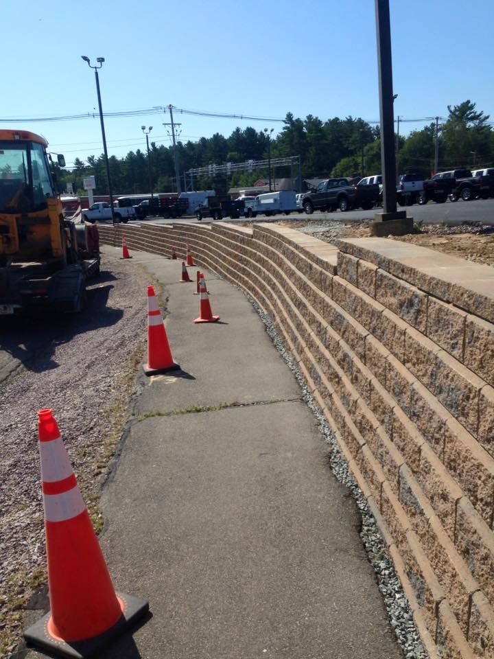 A row of orange and white traffic cones on a sidewalk