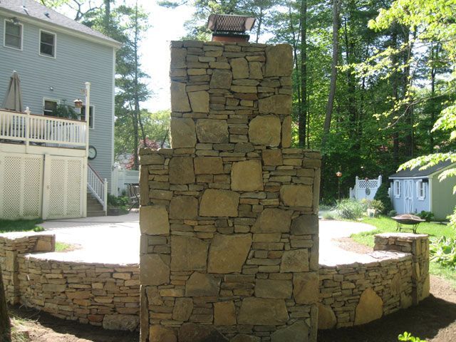 A stone wall with a chimney on top of it