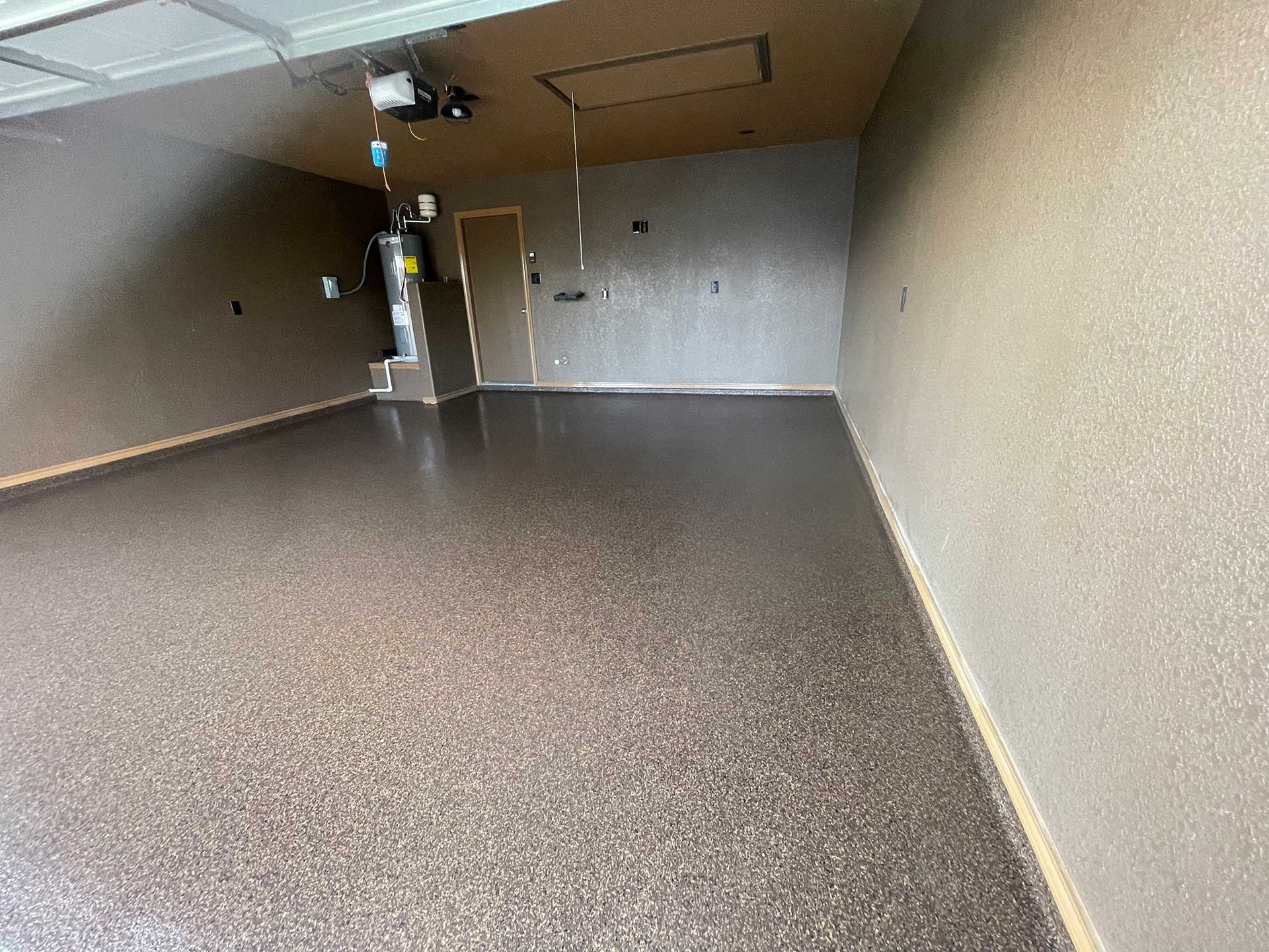 Garage with brown speckled epoxy floor and tan walls.