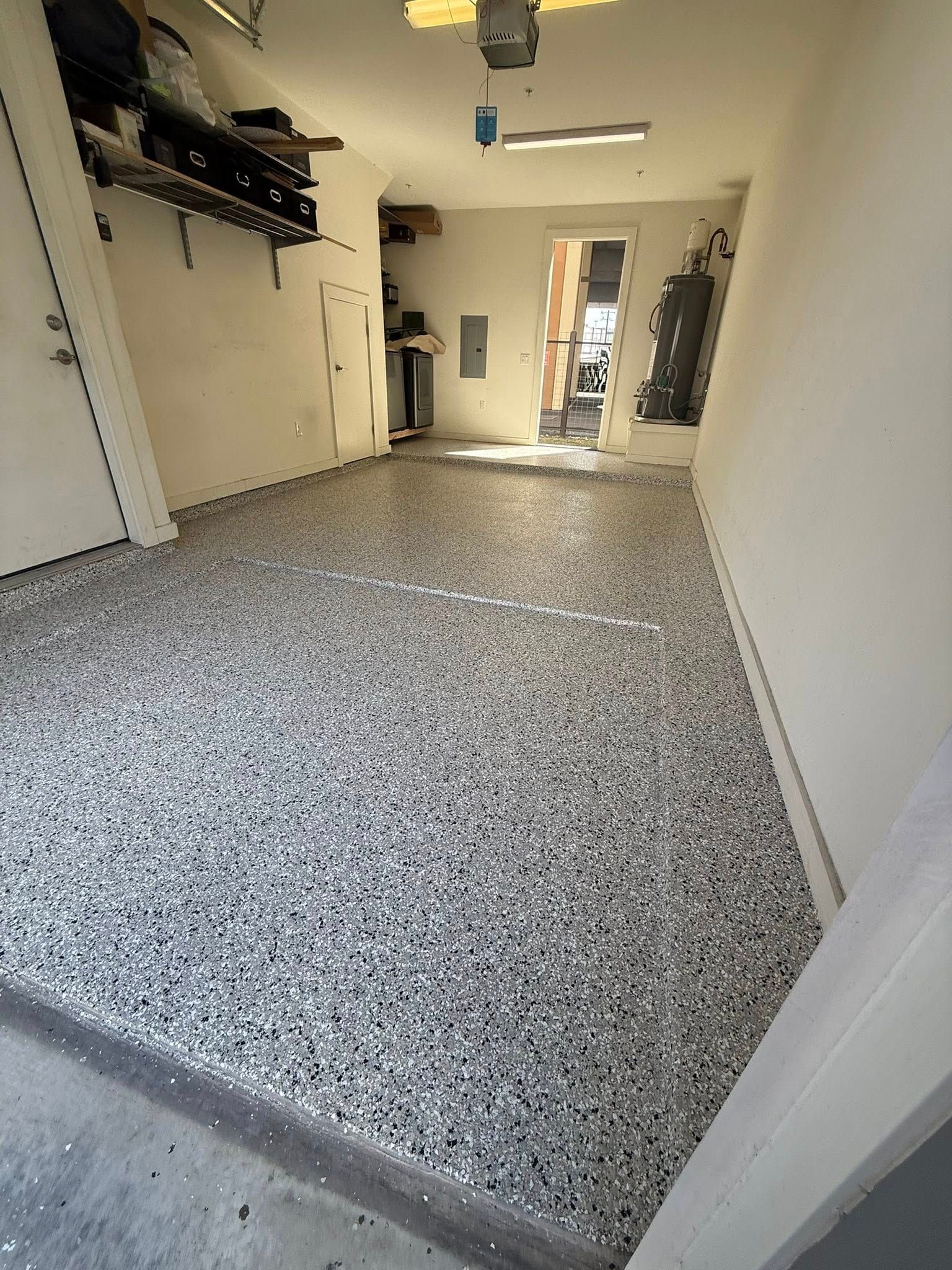 Garage with a speckled, gray epoxy floor.