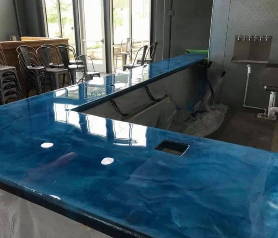 Blue epoxy bar countertop with sink cut-out, in an indoor bar setting.
