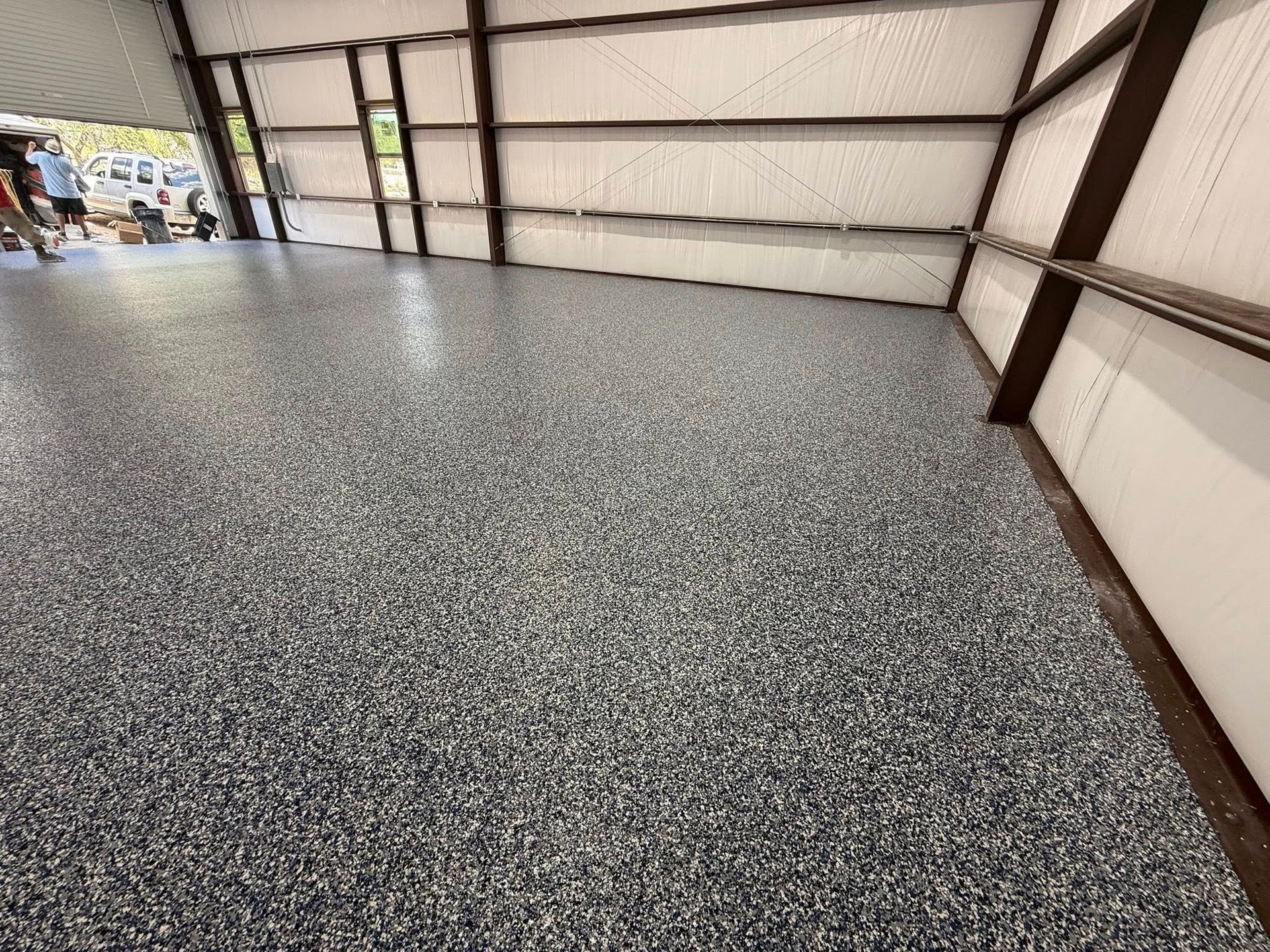 Epoxy-coated floor in a building. The floor is speckled with shades of gray and white.