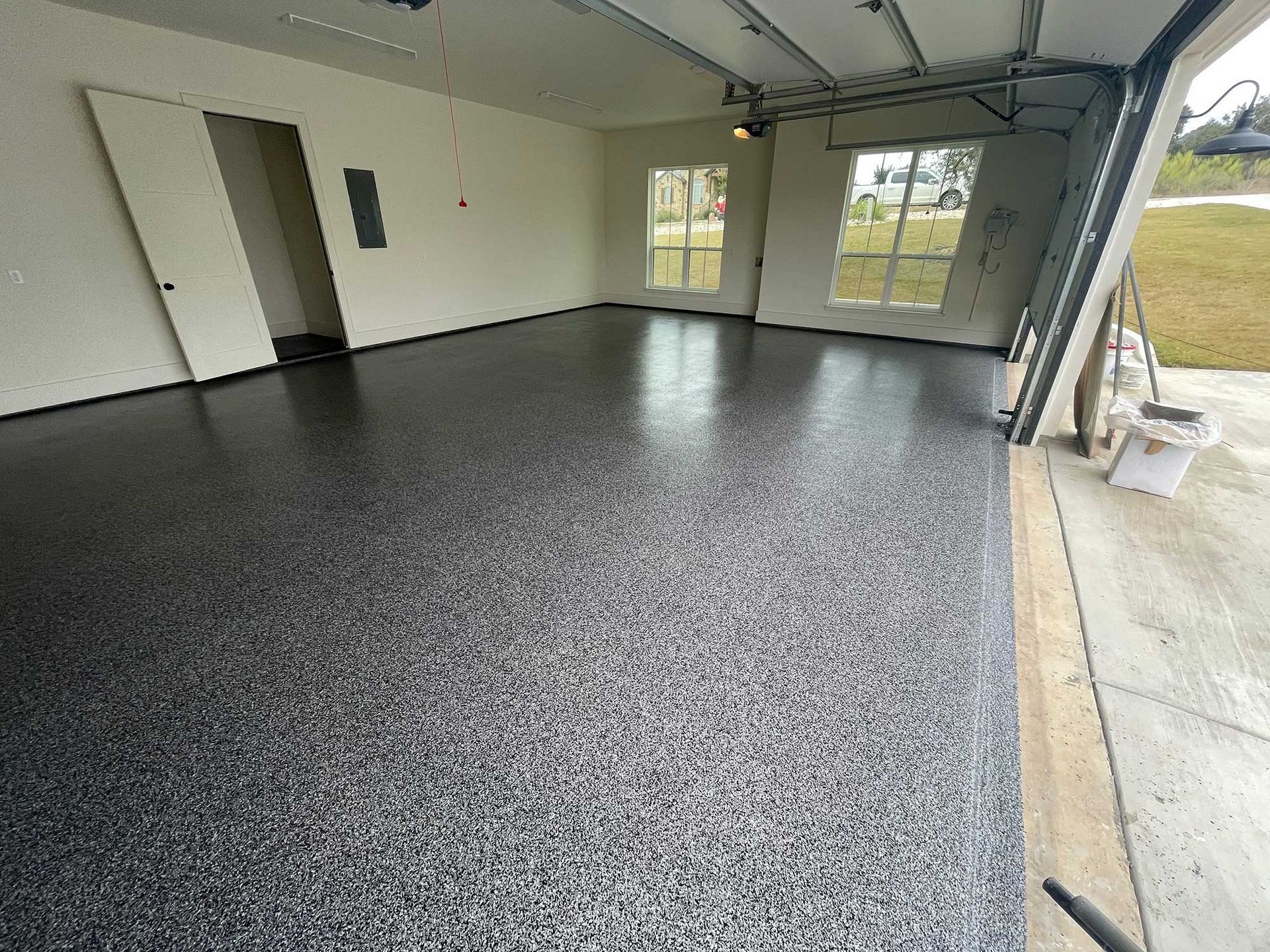 Garage with a polished, speckled black and gray epoxy floor.