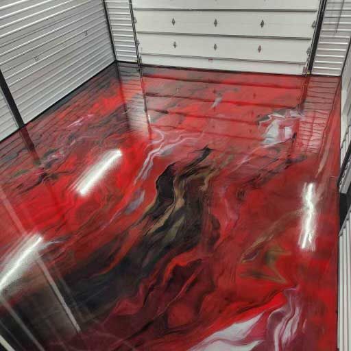 Red and black epoxy garage floor with white and gold accents.