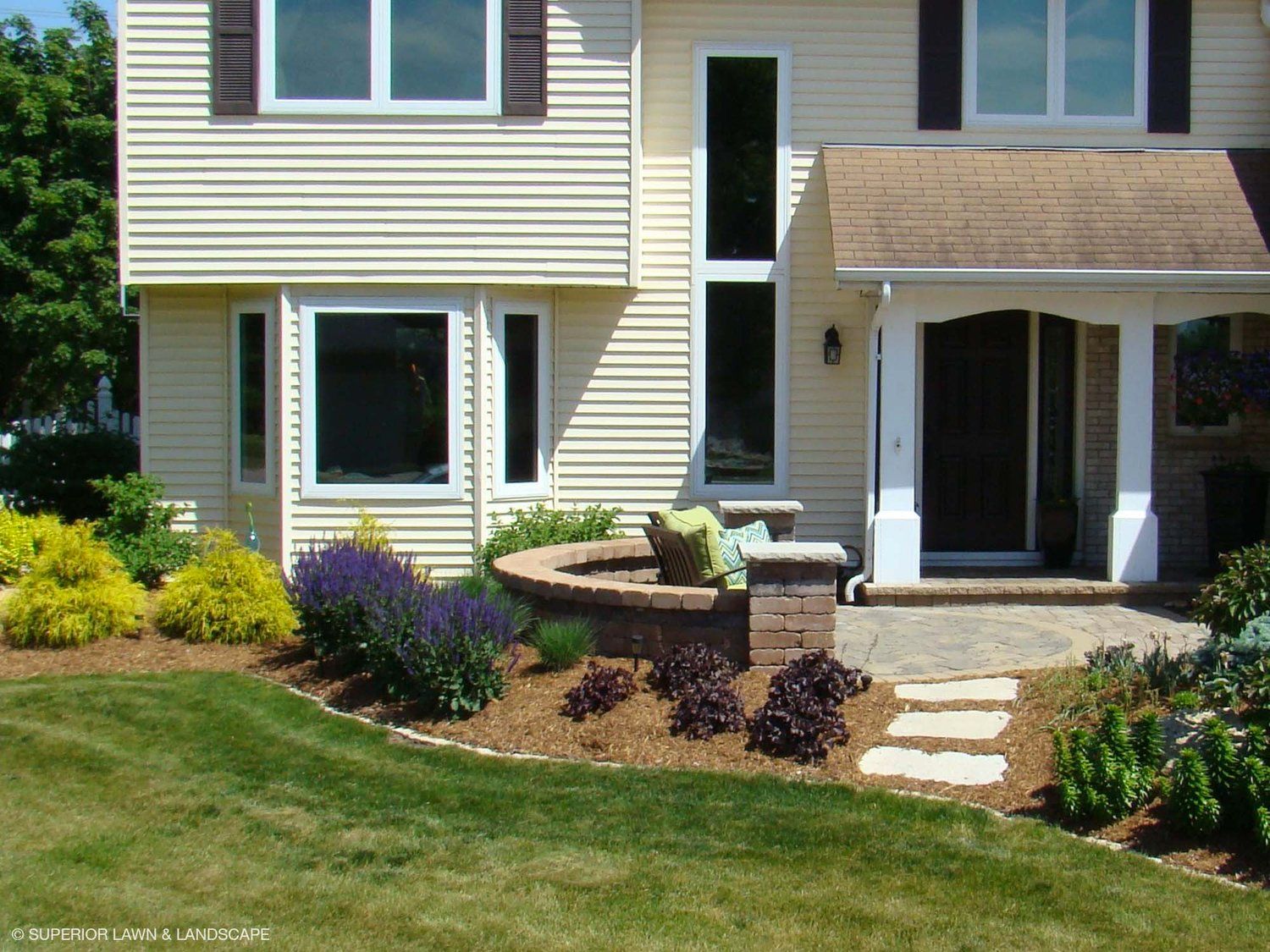 A house with a lush green lawn in front of it