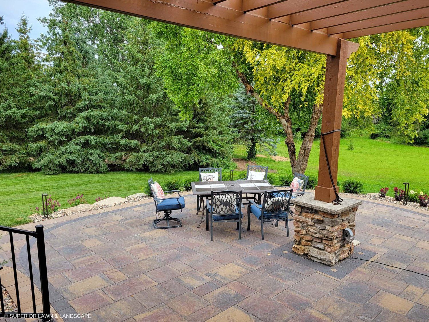A patio with a table and chairs under a pergola.