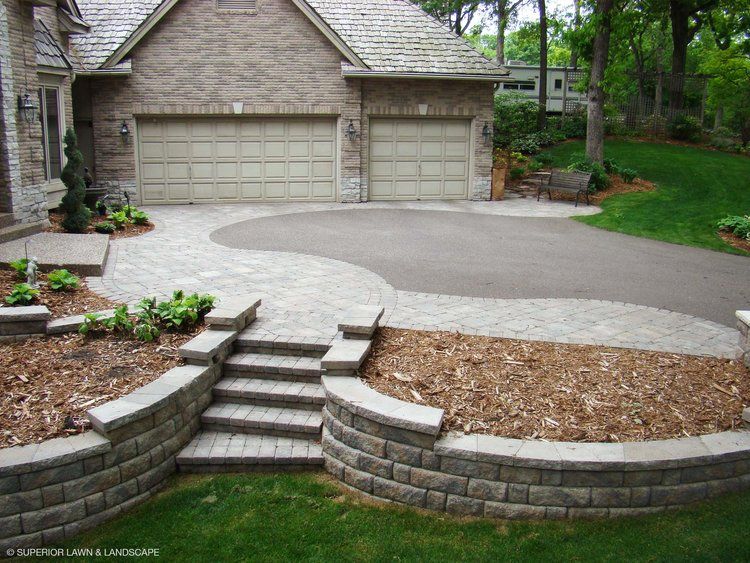 A brick house with two garage doors and a driveway