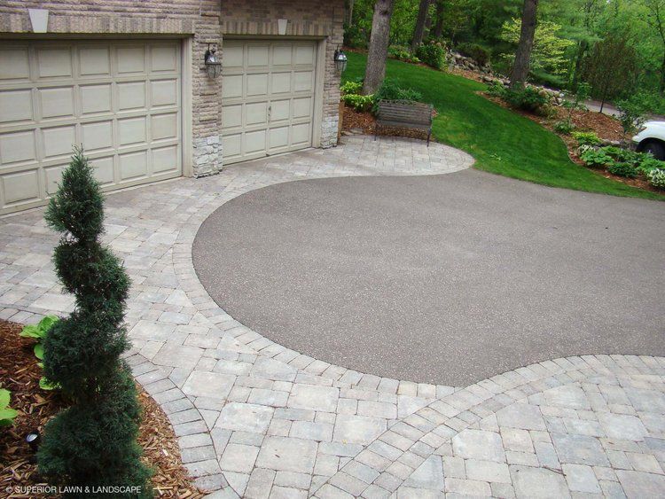 A car is parked in a driveway next to a garage