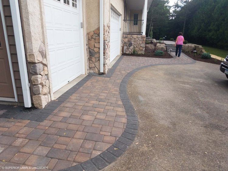 A woman in a pink shirt is walking in front of a garage door