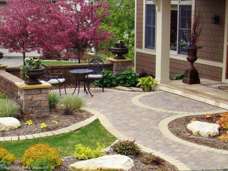 A patio with a table and chairs in front of a house