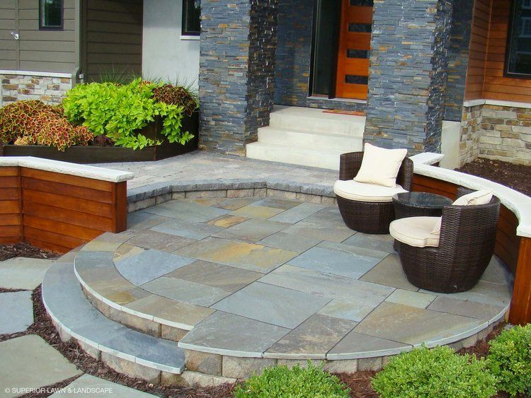 A patio with chairs and a table in front of a house