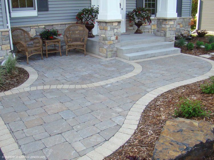 A patio with chairs and a table in front of a house