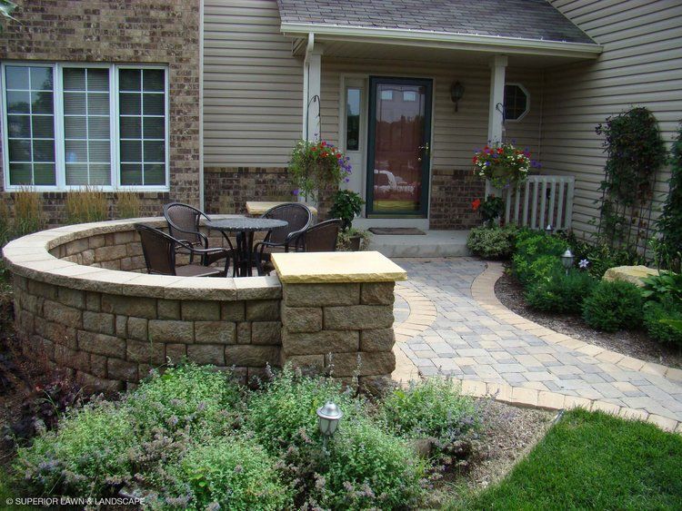 A patio with a table and chairs in front of a house.