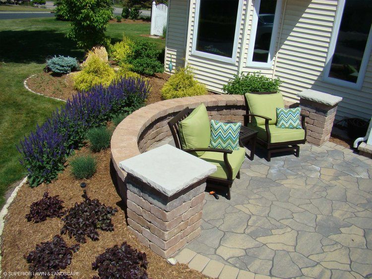 A patio with chairs and a table in front of a house