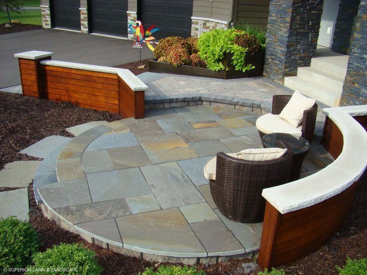 A circular patio with chairs and a table in front of a house