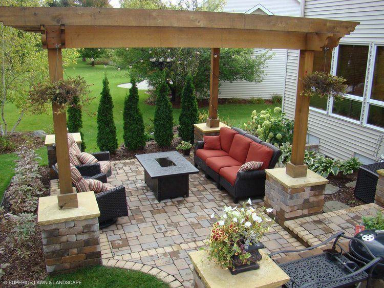 A patio with a couch and chairs under a pergola