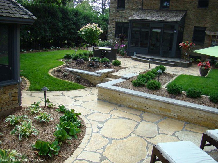 A backyard with a stone walkway leading to a house